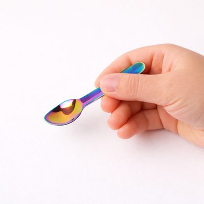 Kleiner Regenbogen Edelstahl Löffel für Kinder in der Hand – zeigt Größe für kleine Hände